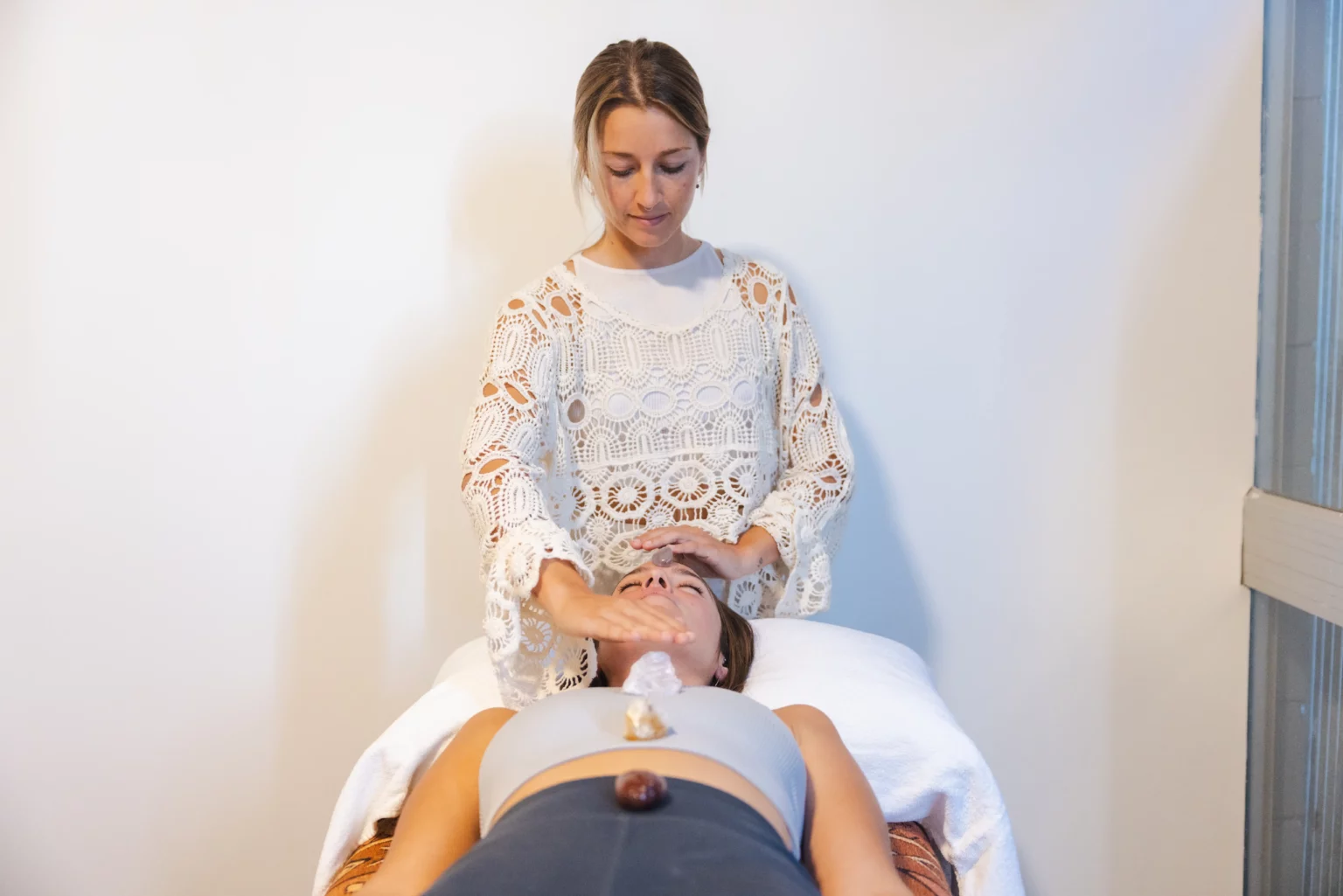 Therapist performing head massage during energy body balance therapy session at Nature Of Wellness