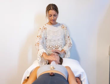 Therapist performing head massage during energy body balance therapy session at Nature Of Wellness