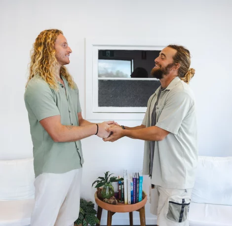 Two men shaking hands and smiling during a therapy session in Currumbin office